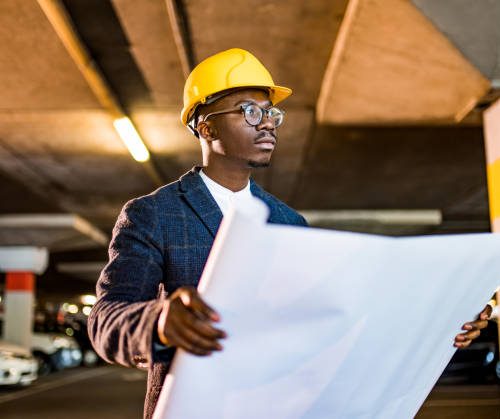 Young African American Engineer working on public car garage project.