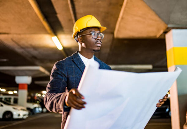 Young African American Engineer working on public car garage project.